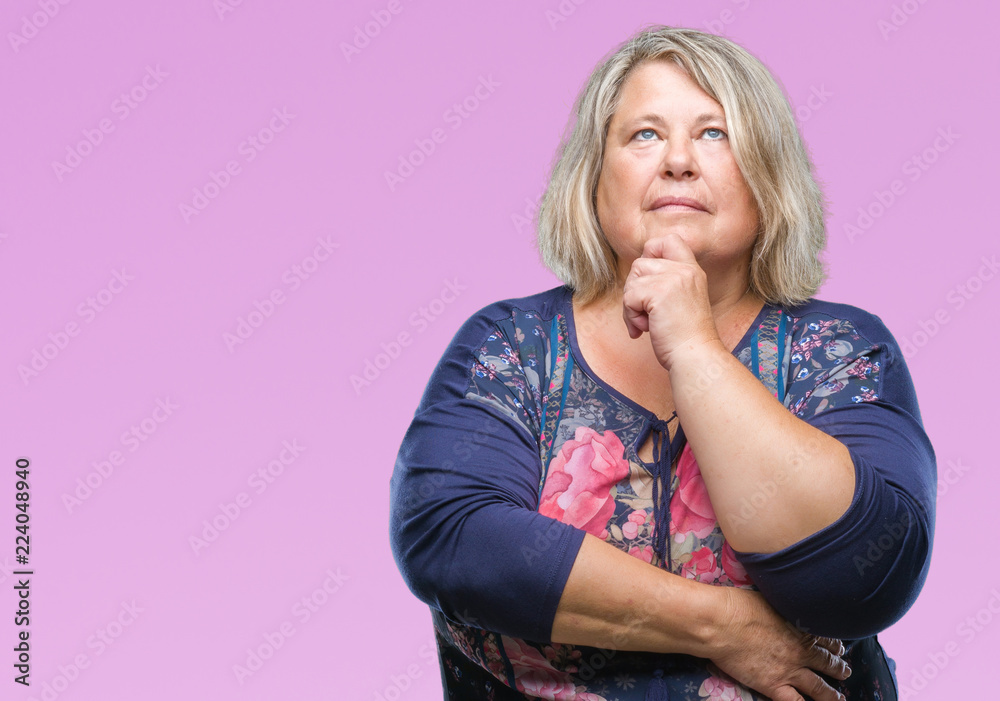 Senior plus size caucasian woman over isolated background with hand on chin thinking about question, pensive expression. Smiling with thoughtful face. Doubt concept.