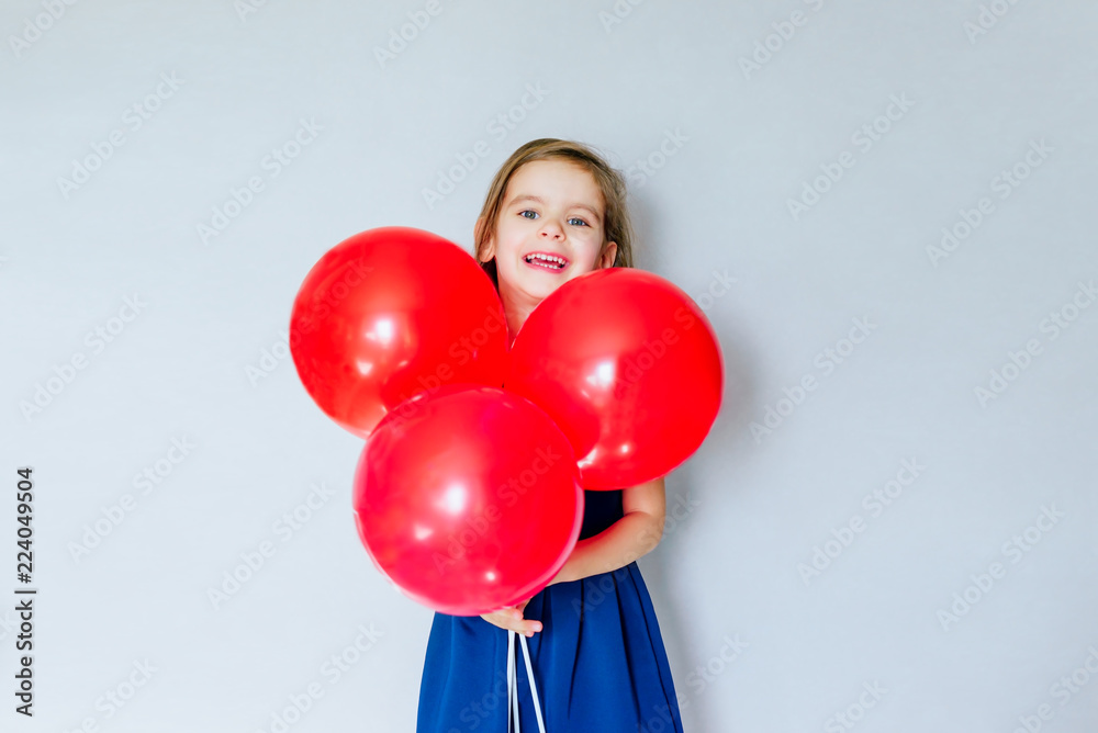 Happy funny girl with red balloon near empty grey concrete walls. Concept of the celebration. Beginning of sales. Black Friday. Happy funny girl with red balloon near empty grey concrete walls. Concept of the celebration. Beginning of sales. Black Friday.