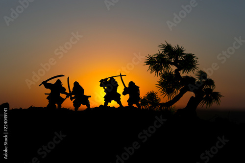 Silhouette of two samurais in duel. Picture with two samurais and sunset sky.