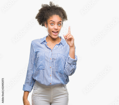 Young afro american woman over isolated background pointing finger up with successful idea. Exited and happy. Number one.