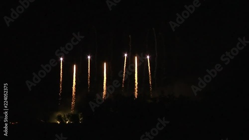 Extract from a huge fireworks display from a festival: A composition of bright lights rising.