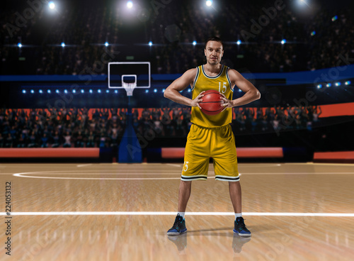 basketball player in yellow uniform standing on basketball court