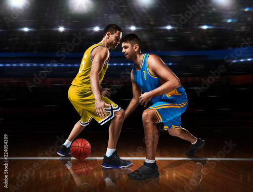 two basketball players in scrimmage on basketball court