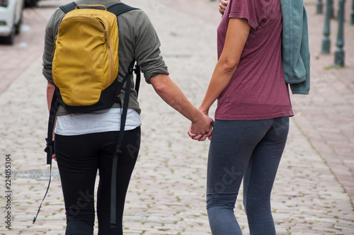 Closeup of lesbian girls shaking hands walking in the street on back view © pixarno
