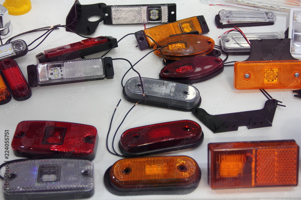 Automotive electric parts texture - New front light, side position lamp and  taillight parking lights 12v and 24v white,yellow and red LED car lamps on  the white background in exhibition showroom Photos