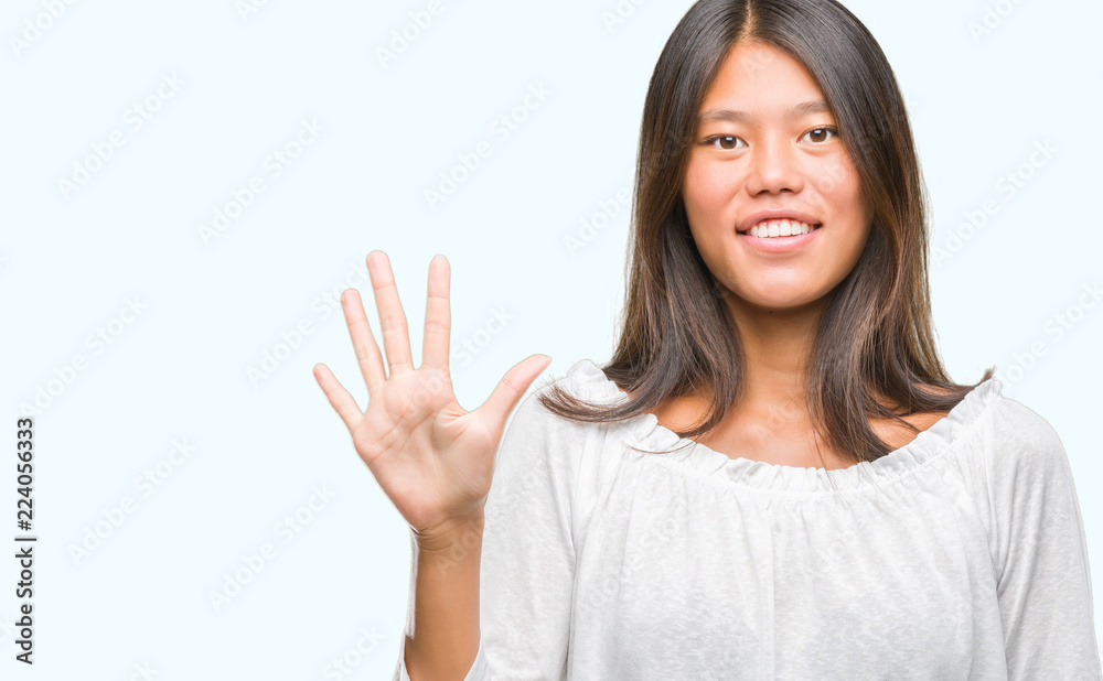 Young asian woman over isolated background showing and pointing up with fingers number five while smiling confident and happy. Young asian woman over isolated background showing and pointing up with fingers number five while smiling confident and happy.