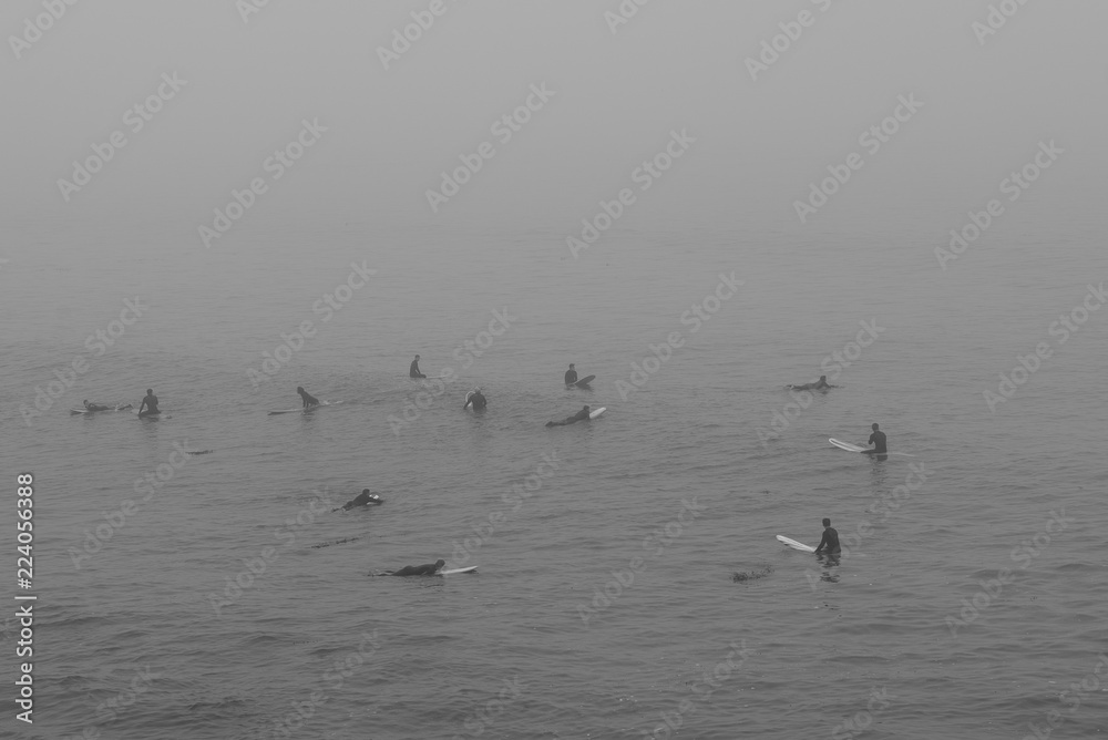 surfers on foggy morning