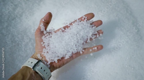 Plastic granules are poured from the hand. Plastic granules, dye, polymer granules are used for the production of plastic products