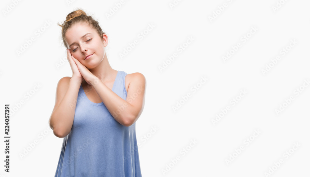 Young blonde woman sleeping tired dreaming and posing with hands together while smiling with closed eyes. Young blonde woman sleeping tired dreaming and posing with hands together while smiling with closed eyes.