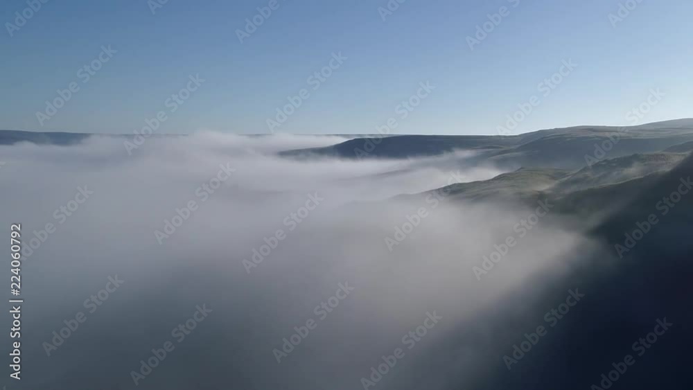 Aerial shot of flying over foggy valley.