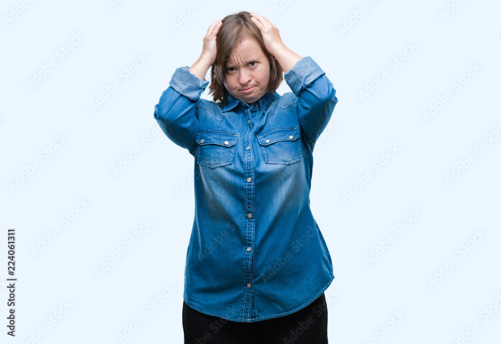 Young adult woman with down syndrome over isolated background suffering from headache desperate and stressed because pain and migraine. Hands on head. Young adult woman with down syndrome over isolated background suffering from headache desperate and stressed because pain and migraine. Hands on head.