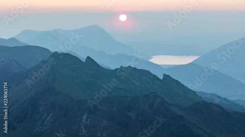 Rosa Sonnenuntergang über Bergen im Dunst