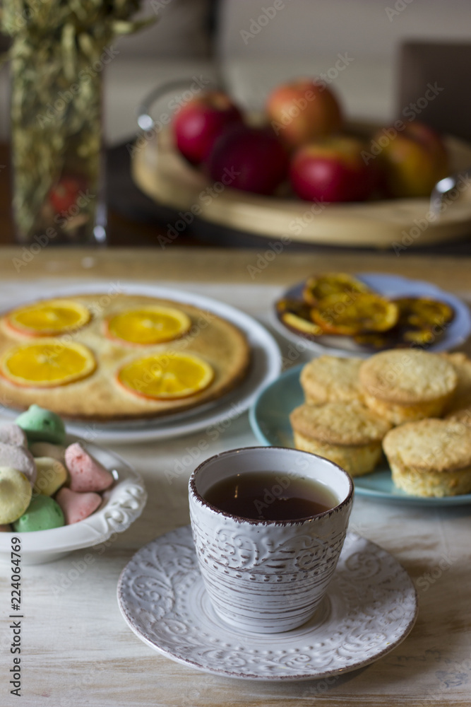Tea with orange tarts and muffins Tea with orange tarts and muffins