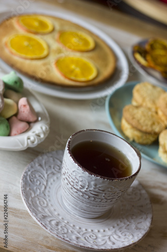 Tea with orange tarts and muffins