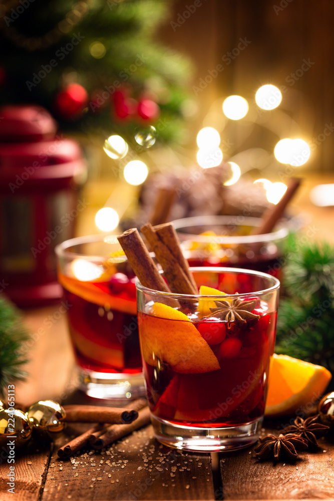 Christmas mulled red wine with spices and oranges on a wooden rustic table. Traditional hot drink at Christmas Christmas mulled red wine with spices and oranges on a wooden rustic table. Traditional hot drink at Christmas