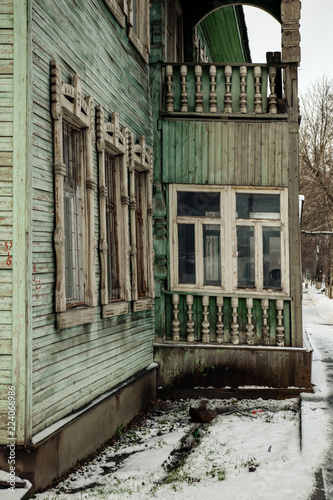 Old green wooden house in winter