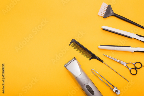 Professional hair dresser tools on yellow background with copy space