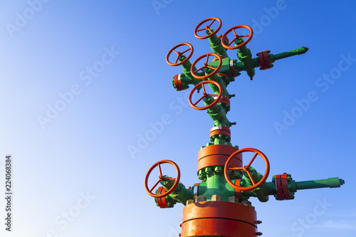 Horizontal view of a wellhead with valve armature. Oil and gas industry concept. Industrial site background. Toned. photo