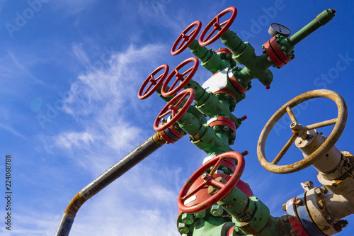 Horizontal view of a wellhead with valve armature. Oil and gas industry concept. Industrial site background. Toned. photo