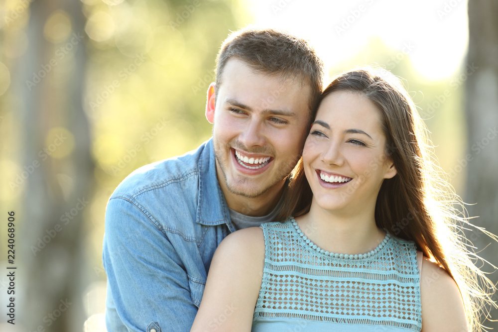 Happy couple looking away in a park Happy couple looking away in a park