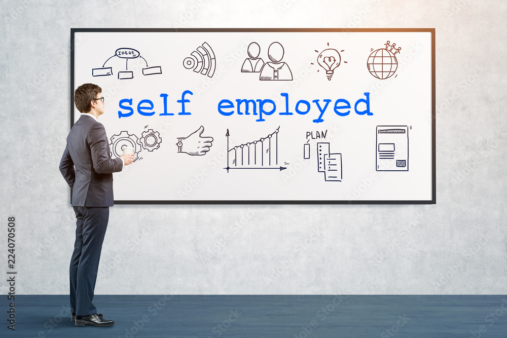 Man looking at self employed icons on whiteboard Man looking at self employed icons on whiteboard