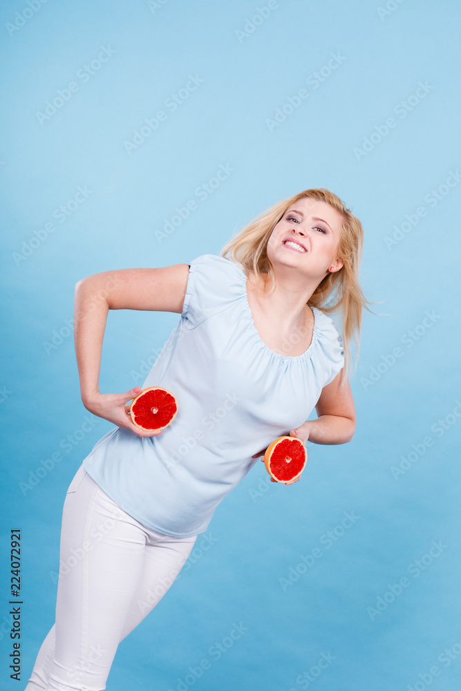 Happy smiling woman holding red grapefruit