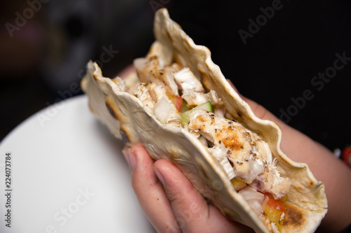 Homemade Traditional Mexican Buritto in hand with white plates photo