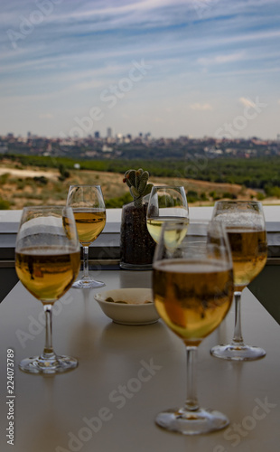 Beers in glasses on a table on the outdoor terrace with the city in the background