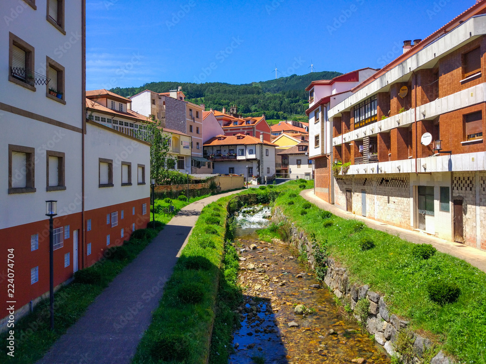 View of a canal with Nonaya river flowing down and buildings at the sides in Salas, Asturias, Spain
