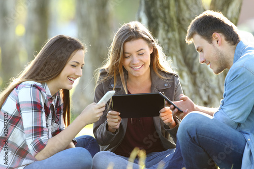Three friends using multiple devices photo