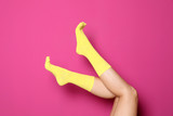 Woman wearing bright socks on color background