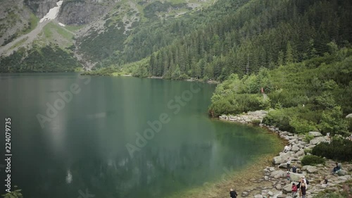 Charming beautiful blue mountain lake with green forest and high mountains in the background Morskie Oko - Poland europe hill landscape nature peak rock sky tatra close up slow motion