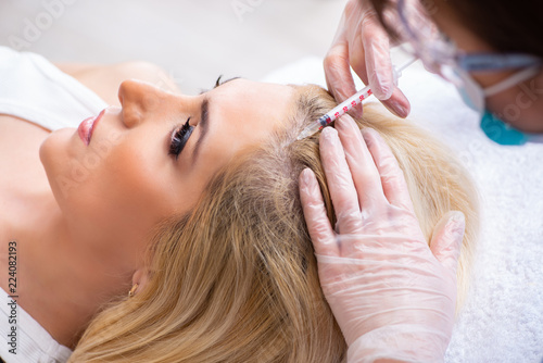 Картината върху платно Plastic surgeon preparing for operation on woman hair