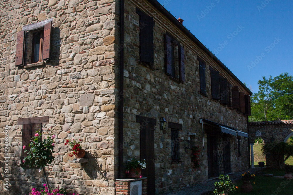 Stone house with blue sky and trees background.