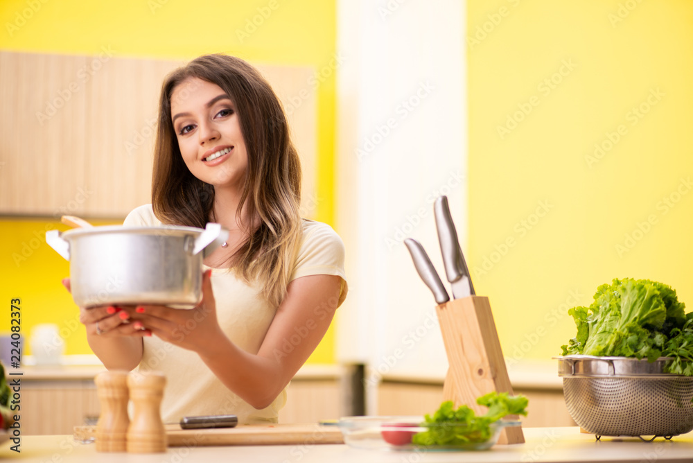 Young woman cooking soup in kitchen at home Young woman cooking soup in kitchen at home