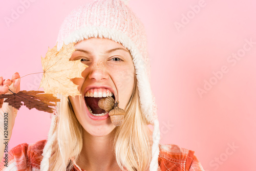 Happy young woman are preparing for autumn sale day. Surprise woman playing with acorn and looking at camera. Happy girl Having fun. Isolated object on pink background. Surprise woman.