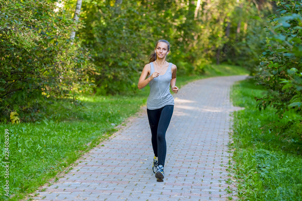 Running woman atletic spotsman trains in the summer park. Outdoor fitness portrait Running woman atletic spotsman trains in the summer park. Outdoor fitness portrait