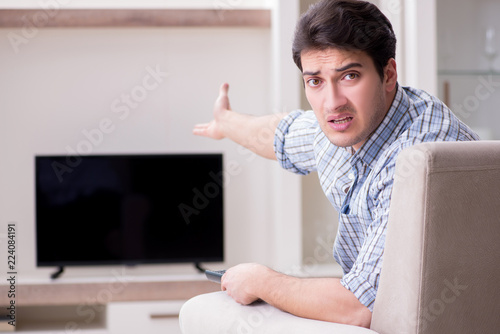 Konstfotografi Young man watching tv at home