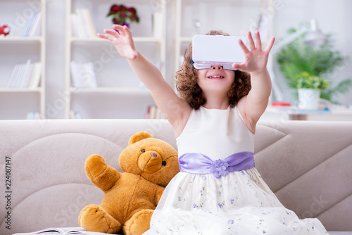 Young little girl with VR virtual reality glasses photo