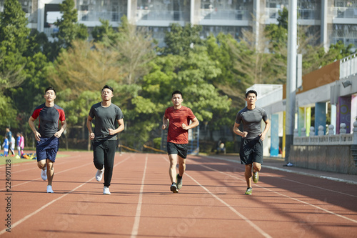 young asian athletes running on track photo