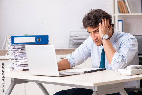 Overloaded busy employee with too much work and paperwork