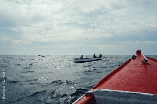 local fisherman in a big group hunting for yellow fin tuna or other game fish in traditional boats or dinghies photo