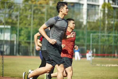 Fototapeta Naklejka Na Ścianę i Meble -  young asian athletes running on track