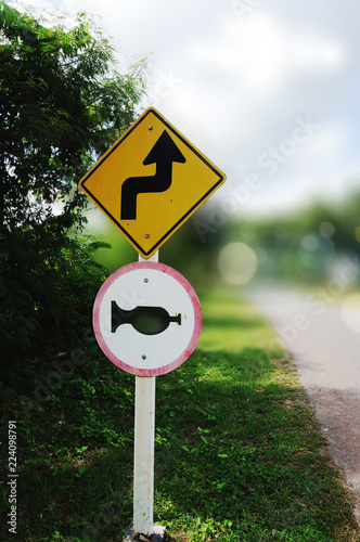 Double sharp curve and give horn traffic signs at the roadside
