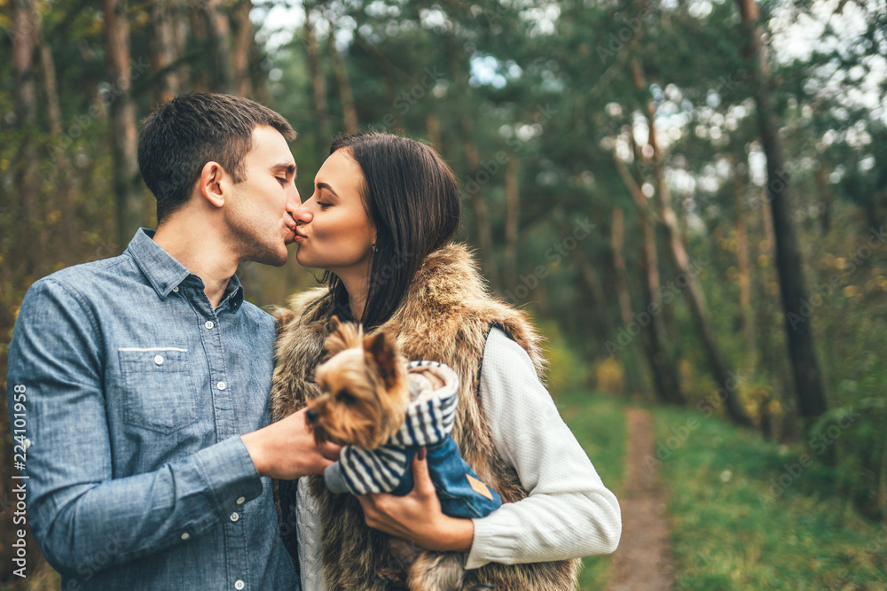 Pretty couple with little yorkshire terrier walking in the forest. Pretty couple with little yorkshire terrier walking in the forest.