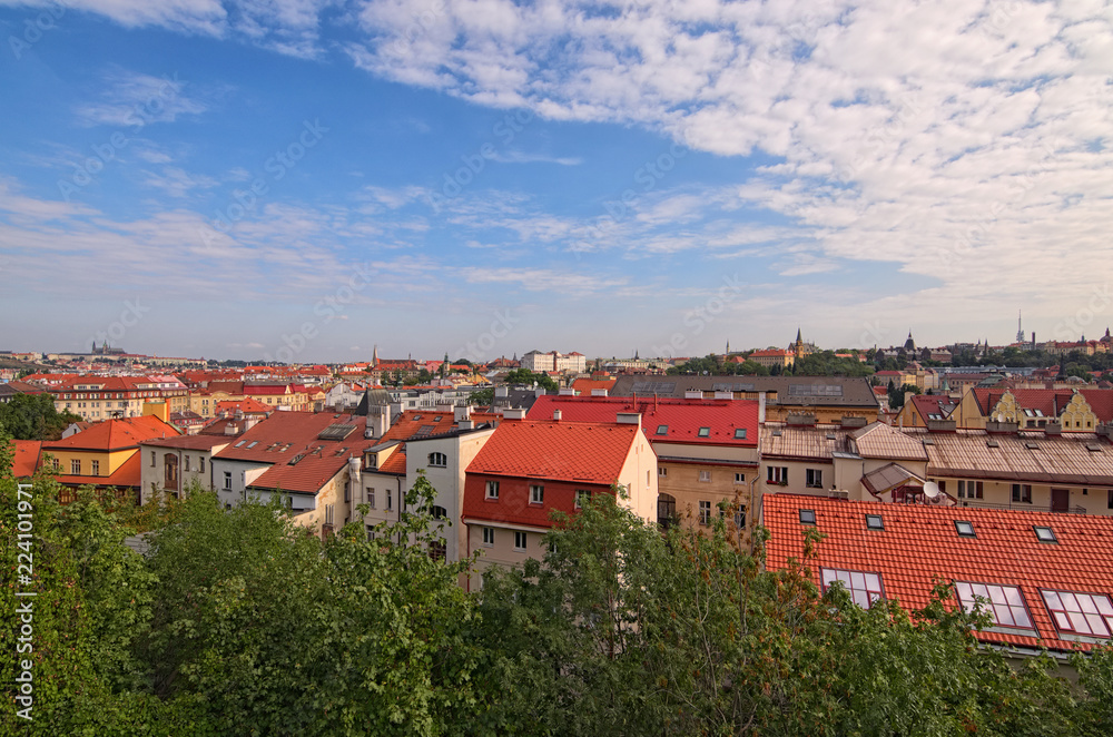 Aerial view of residential district in Prague. Buildings with red tile roofs, a lot of trees. Colorful vibrant sky. Summer landscape photo on a sunny morning. Prague, Czech Republic