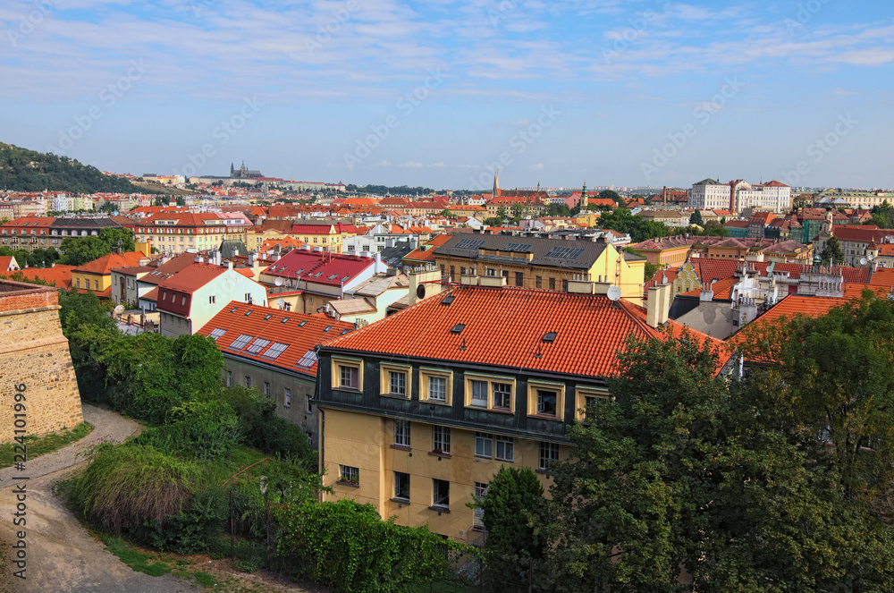 Aerial view of residential district in Prague. Buildings with red tile roofs, a lot of trees. Colorful vibrant sky. Summer landscape photo on a sunny morning. Prague, Czech Republic