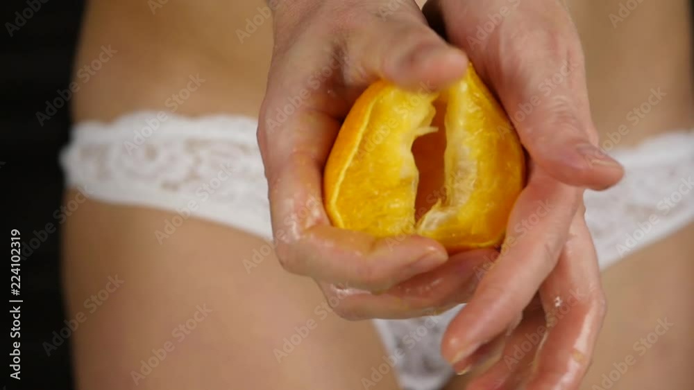 woman's hands squeezes juice from an orange, slow motion woman's hands squeezes juice from an orange, slow motion