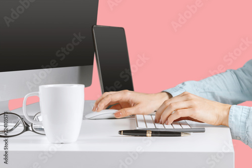 Young woman sitting at the table with open netbook computer. Female person using modern technology.