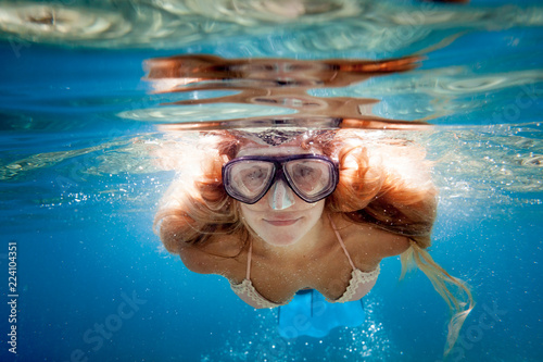 Beautiful woman underwater snorkeling in the clear tropical water